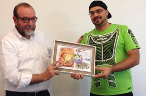 Ricardo Gomes (MSO Eurogames World Champion) gives the Quina d’Ouro 2016 prize for the boardgame <em>Auf den Spuren von Marco Polo</em>